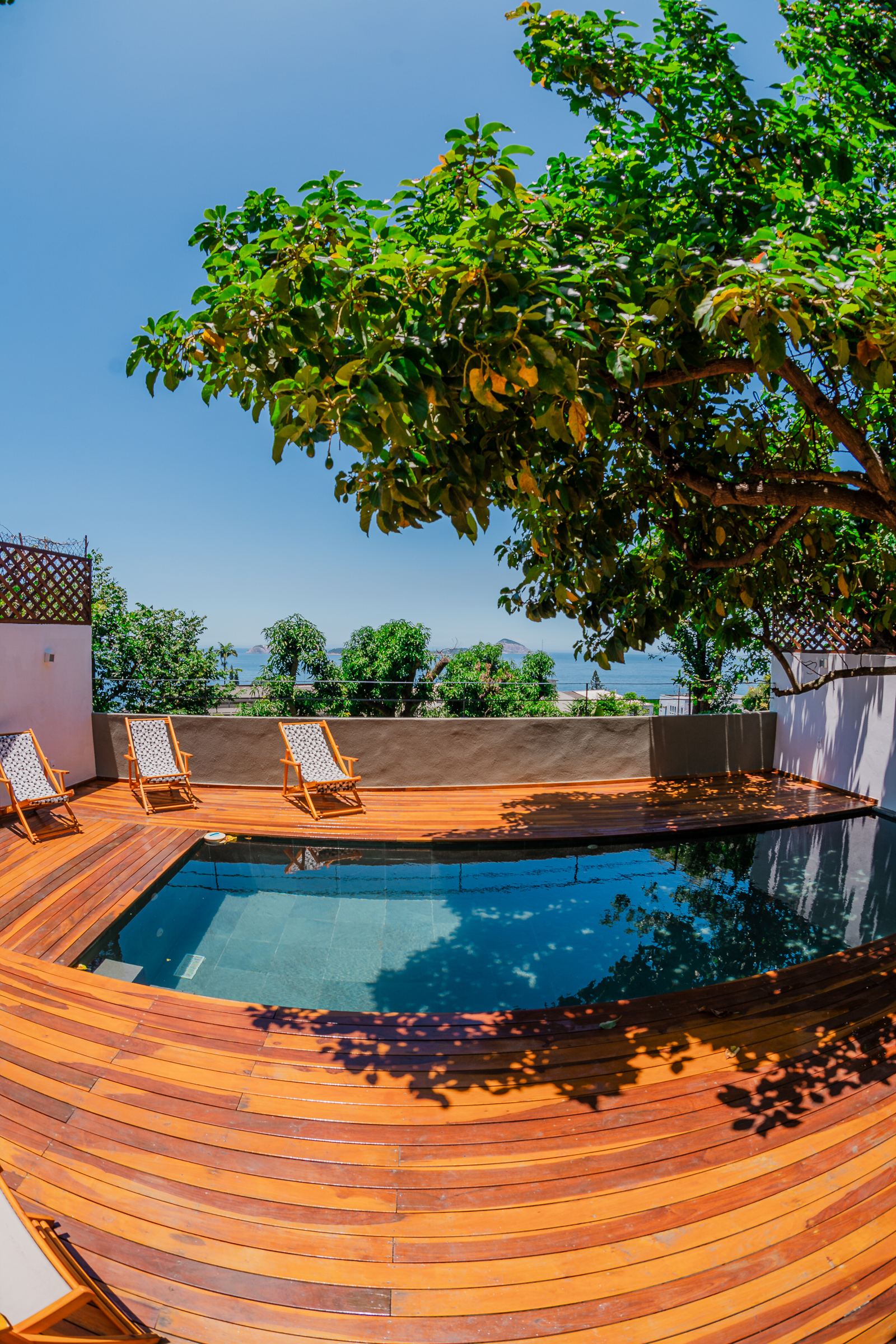 Piscine et deck en ipé de Vila Oriba sous l'arbre, chaises longues face à la mer