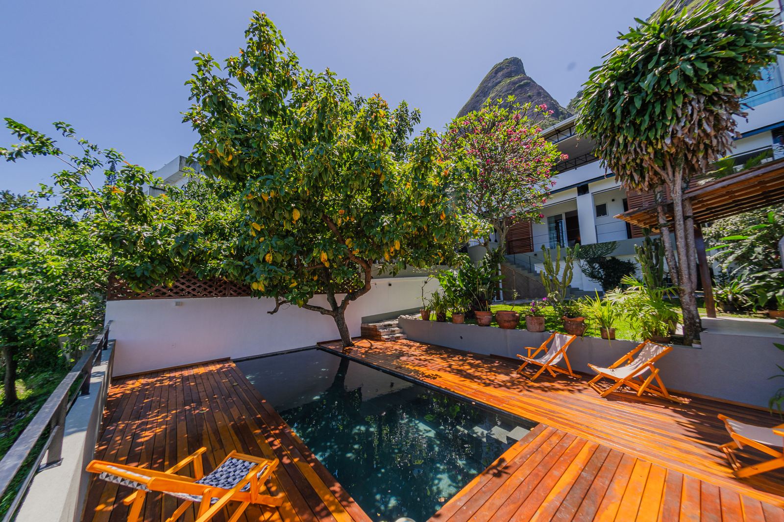 Jardin de Vila Oriba avec piscine, deck et chaises longues, morne Dois Irmãos derrière