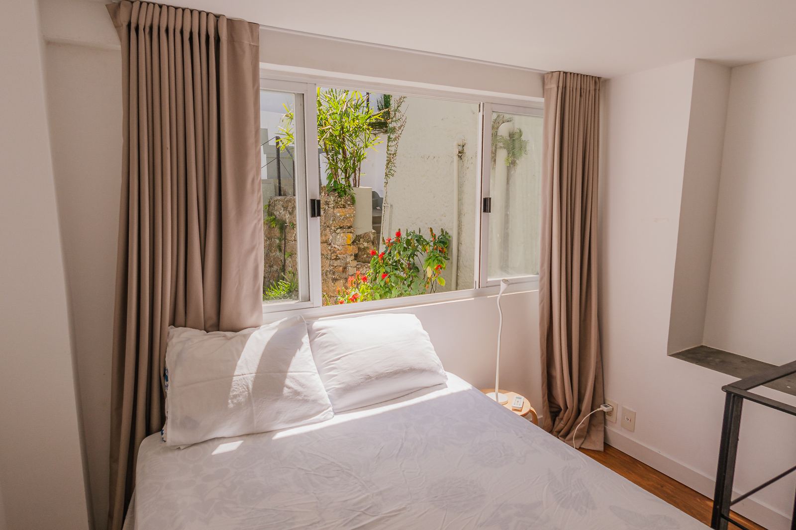 Suite de Vila Oriba côté jardin, lit double et rideaux