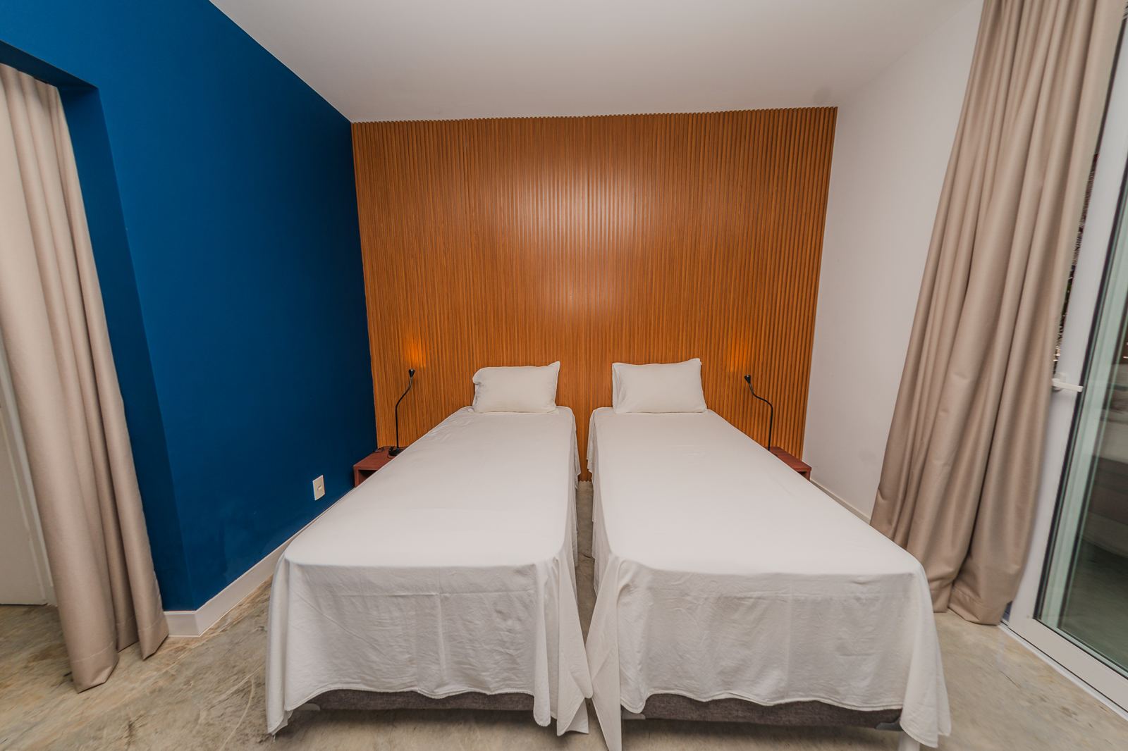 Suite de Vila Oriba à deux lits simples, mur bleu et tête de lit en bois